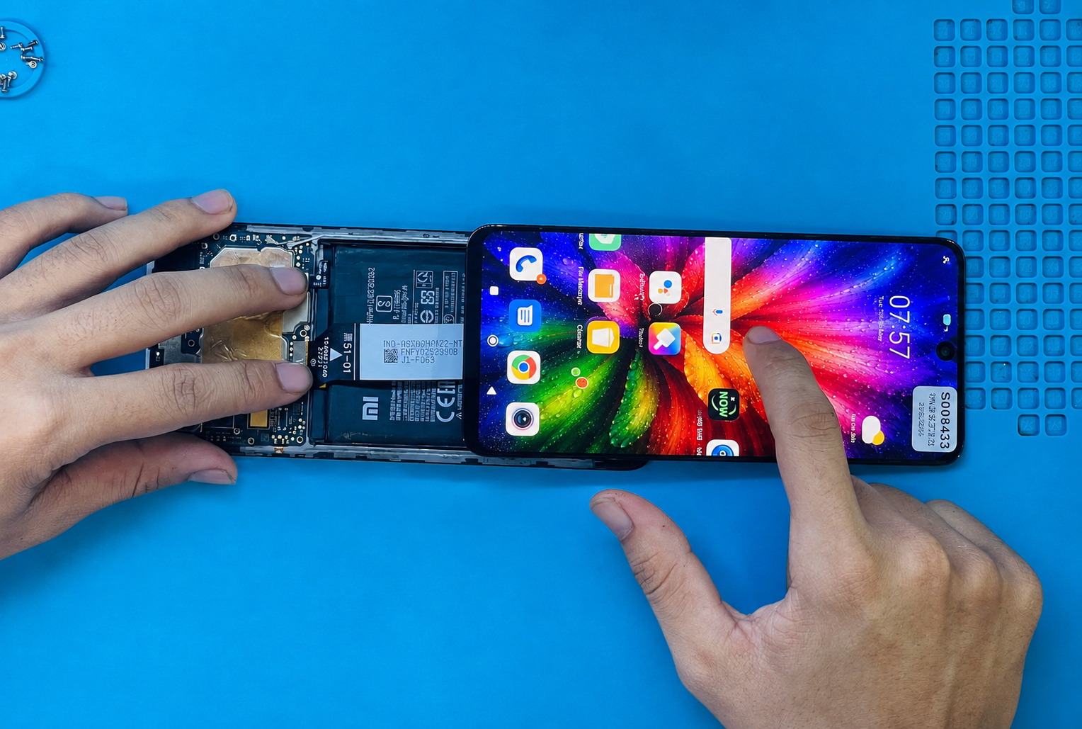 Technician testing a replacement phone display and touch response during repair